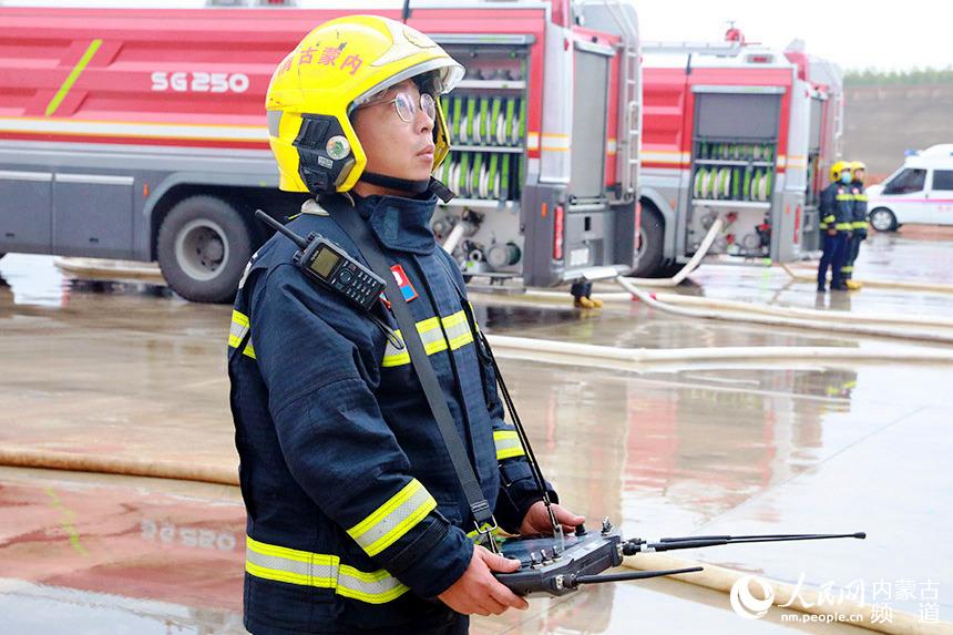 演練滅火現場消防員操控機器人滅火。人民網 李睿攝