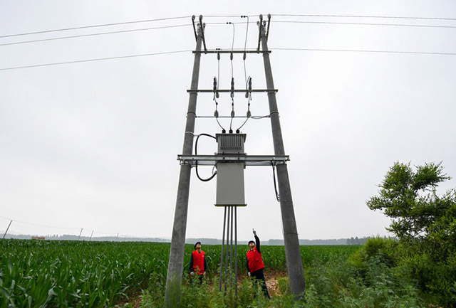 7月6日,國家電網蒙東電力(科右前旗)科爾沁鎮供電所共產黨員服務隊隊員在農田間檢查變壓器的運行情況。新華社記者 彭源 攝