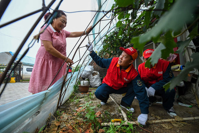 7月6日,國家電網蒙東電力(科右前旗)科爾沁鎮供電所共產黨員服務隊隊員為農戶解決大棚灌溉問題。新華社記者 彭源 攝