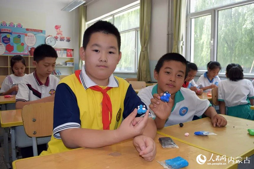 包頭市青山區(qū)根據(jù)學(xué)生布局，在南北部各指定2所中小學(xué)開展托管服務(wù)，由學(xué)生自愿、就近選擇相應(yīng)學(xué)校。北重一小的學(xué)生在做手工捏塑。段學(xué)敏攝