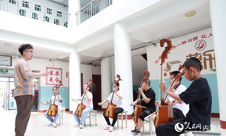 孩子們饒有興趣地學(xué)習(xí)拉馬頭琴。陳先達(dá)攝