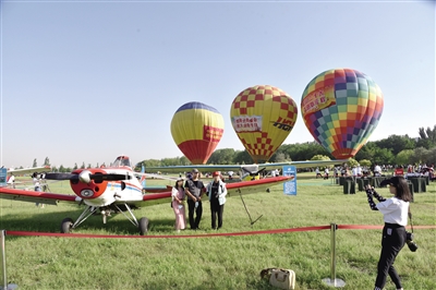 游客爭相與航空嘉年華中的各類飛機合影。郝飚 攝