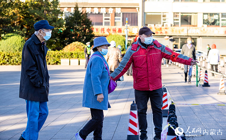 呼和浩特市玉泉區一處核酸篩查點，工作人員引導老年人通過綠色通道接受核酸檢測。丁根厚攝