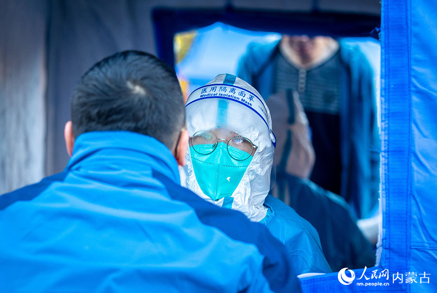 呼和浩特市玉泉區(qū)一處核酸采樣點(diǎn),醫(yī)護(hù)人員為居民進(jìn)行核酸檢測(cè)。丁根厚攝