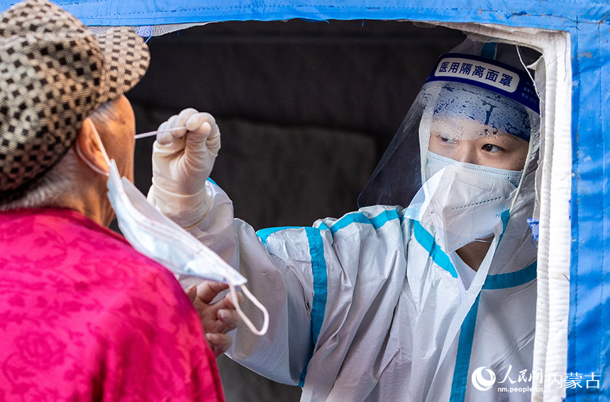 呼和浩特市玉泉區一處核酸篩查點,醫護人員為居民進行核酸檢測。丁根厚攝