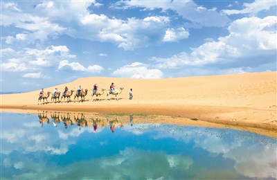 游客在烏海湖旅游區享受沙漠風光。烏海湖東臨烏海市濱河景觀帶,西接烏蘭布和沙漠,南接黃河烏海段上段河道,北接水利樞紐大壩,豐富的景觀與平靜如鏡的湖水融為一體,讓人流連忘返。本報記者 懷特烏勒斯 攝