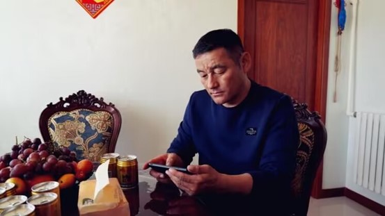 吉仁浩亞在手機屏幕上遠程操作智慧羊棚