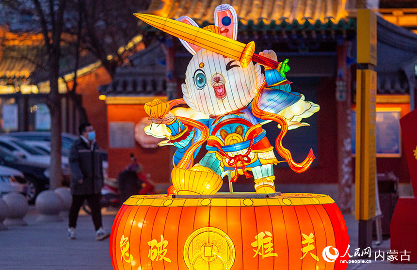 1月18日晚，游客從呼和浩特市玉泉區(qū)塞上老街歷史文化街區(qū)“兔破難關(guān)”花燈旁經(jīng)過。丁根厚攝