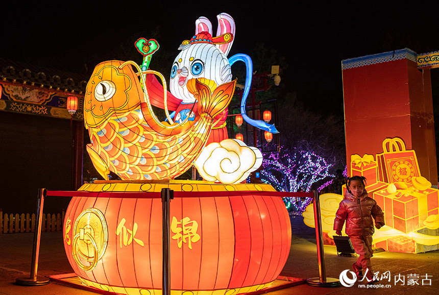 1月18日晚，小朋友在呼和浩特市玉泉區塞上老街歷史文化街區的“玉兔”花燈旁游玩。丁根厚攝