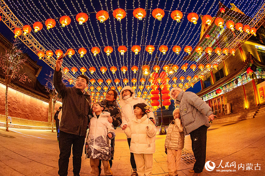 1月18日晚，游客在呼和浩特市玉泉區塞上老街歷史文化街區燈籠長廊下自拍留影。丁根厚攝