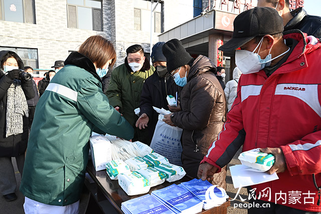 賽罕區太平莊中心衛生院工作人員為村民發放防疫物資及人民網編寫的防疫手冊。人民網 劉藝琳攝