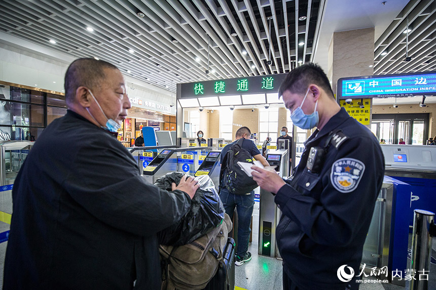 二連出入境邊防檢查站執(zhí)勤民警為旅客提供通關(guān)咨詢引導(dǎo)。胡富國攝
