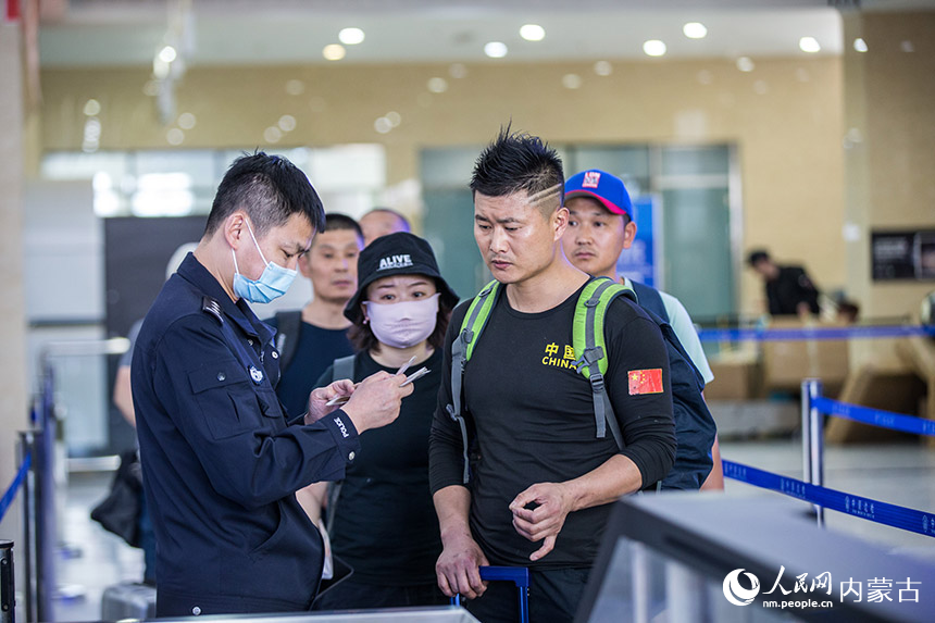 二連出入境邊防檢查站執(zhí)勤民警為旅客提供通關(guān)咨詢引導(dǎo)。胡富國攝