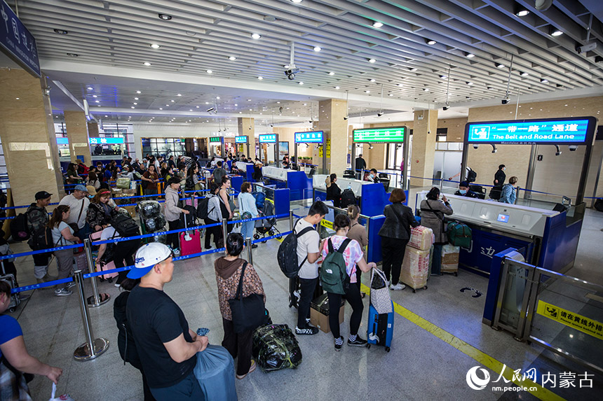 二連出入境邊防檢查站執勤民警為旅客辦理通關手續。胡富國攝