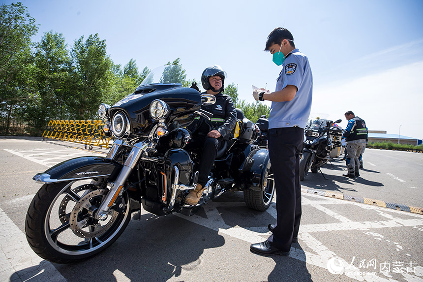 二連出入境邊防檢查站執勤民警查驗自駕旅游團成員通關證件。胡富國攝