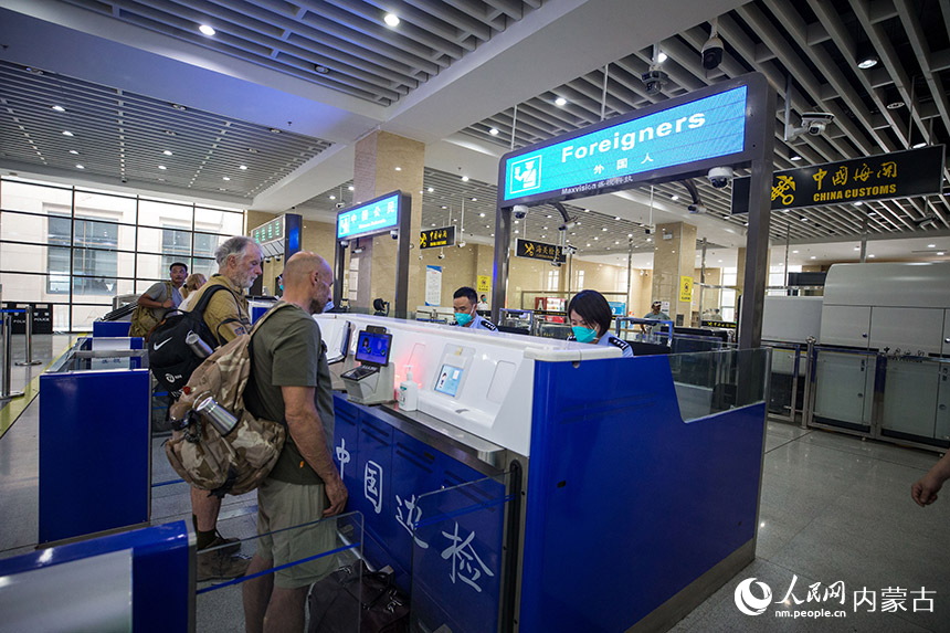 二連出入境邊防檢查站移民管理警察為自駕旅游團辦理入境通關手續。郭鵬杰攝