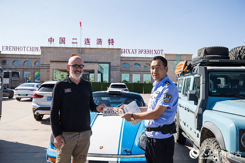 為自駕旅游團(tuán)成員發(fā)放臨時(shí)入境號(hào)牌。郭鵬杰攝