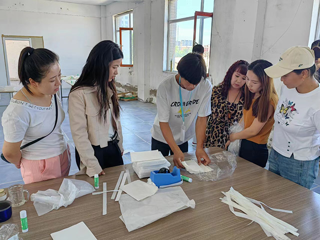 零工市場工作人員向零工演示紙圍裙的做法。云美玲攝