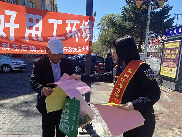 工作人員為群眾發(fā)放勞動保障法律法規(guī)宣傳單。白薇攝