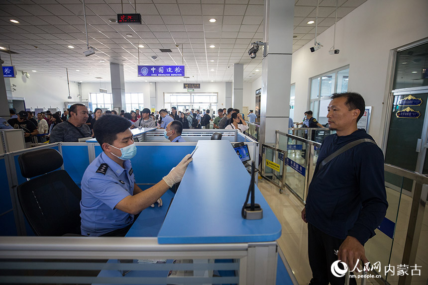 二連出入境邊防檢查站執勤民警為參加中蒙博覽會的旅客辦理入境通關手續。郭鵬杰攝