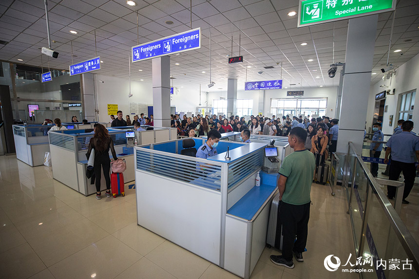 二連出入境邊防檢查站執勤民警為參加中蒙博覽會的旅客辦理入境通關手續。郭鵬杰攝