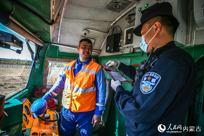 二連出入境邊防檢查站執(zhí)勤民警查驗(yàn)列車員工出入境證件。郭鵬杰攝