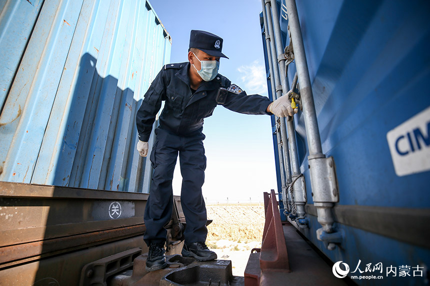 二連出入境邊防檢查站執勤民警對中歐班列進行車體檢查。郭鵬杰攝