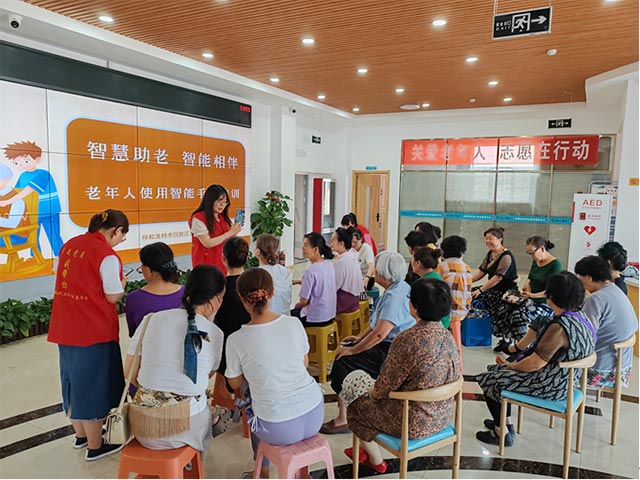 社區工作人員對老年人進行智能手機使用培訓。