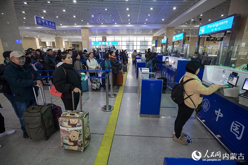 二連出入境邊防檢查站民警為旅客辦理通關手續。郭鵬杰攝