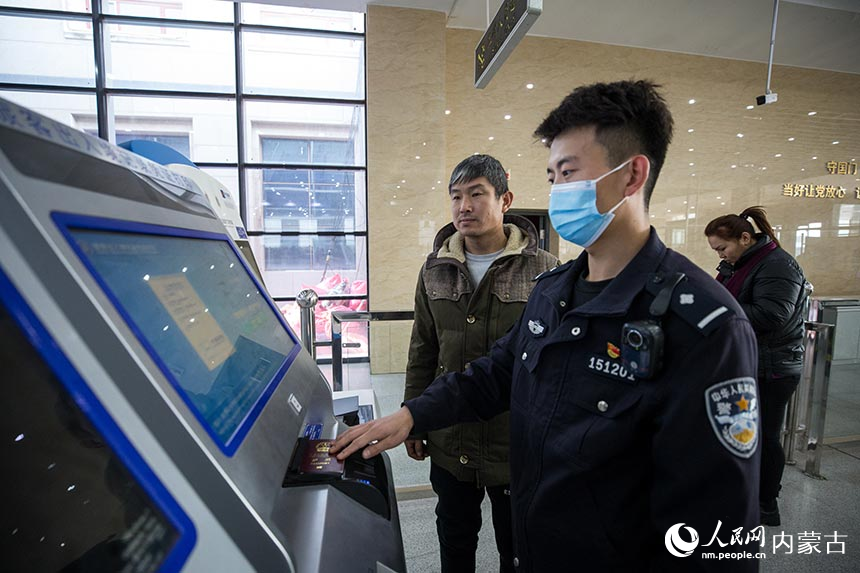 二連出入境邊防檢查站移民管理警察為旅客打印自助通關(guān)憑證。郭鵬杰攝