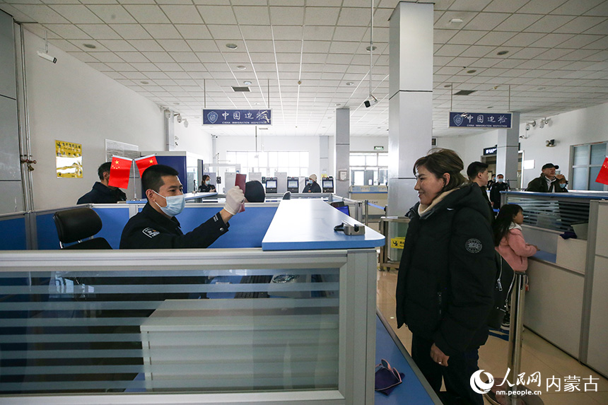 二連出入境邊防檢查站移民管理警察為旅客辦理通關手續。郭鵬杰攝