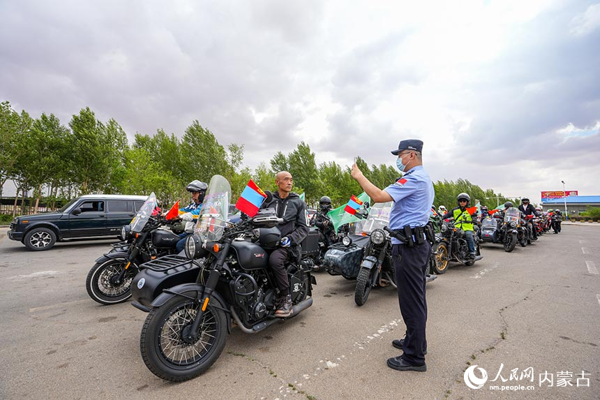 二連出入境邊防檢查站移民管理警察查驗摩托車自駕旅游團成員通關證件。楊金燁攝
