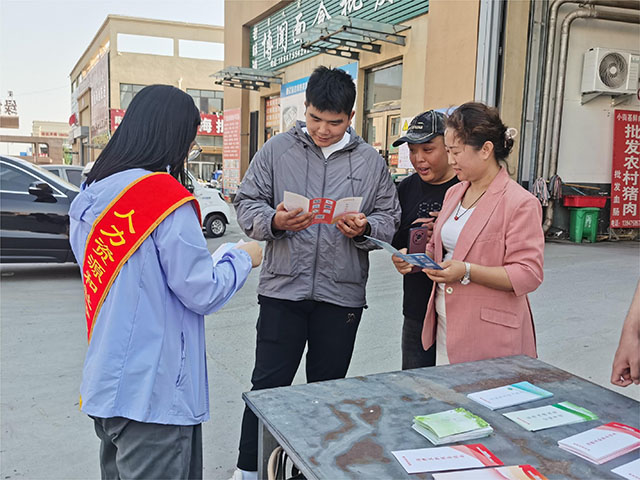 工作人員在農貿市場宣傳政策。徐文博攝