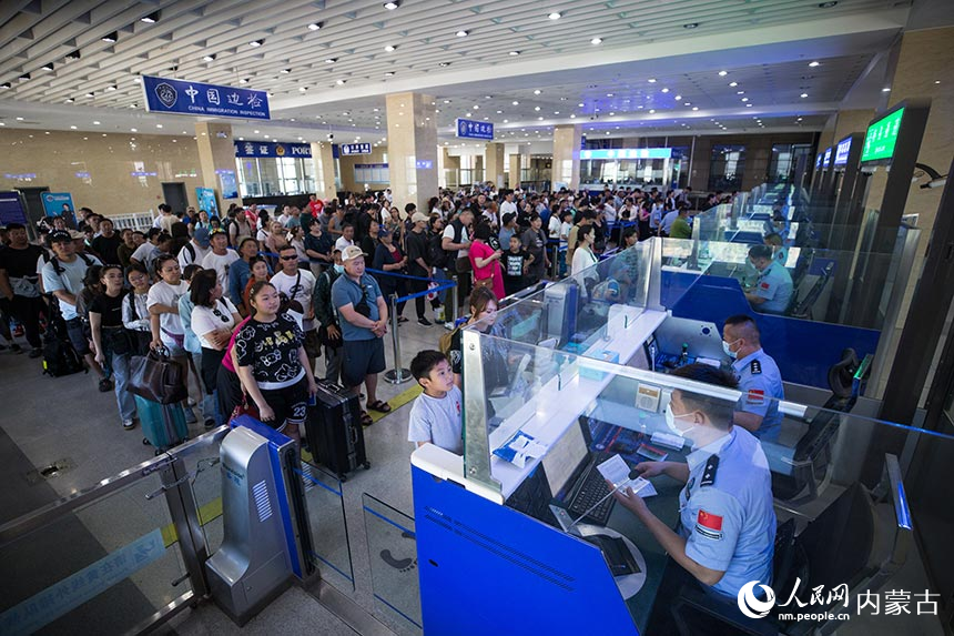 二連出入境邊防檢查站移民管理警察為旅客辦理通關手續。郭鵬杰攝