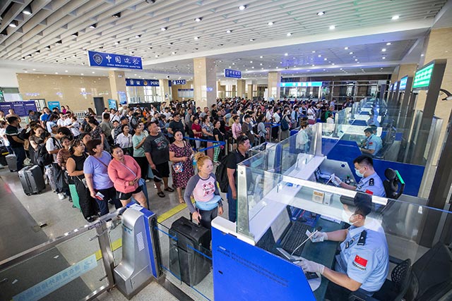 二連出入境邊防檢查站執勤民警為旅客辦理通關手續。