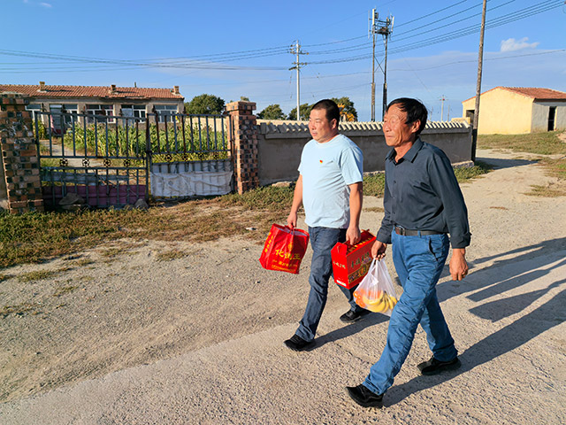 圖為9月12日,內(nèi)蒙古化德縣崩巴圖村黨支部書記李國(guó)成(圖左)和村干部去慰問看望村中老人。記者 張棖攝