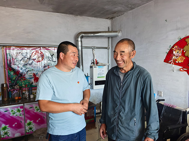 圖為9月12日,內(nèi)蒙古化德縣崩巴圖村黨支部書記李國(guó)成(圖左)慰問看望75歲的李德金老人。記者 張棖攝