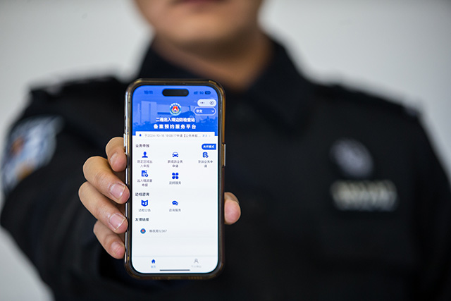 圖1：2024年10月31日，二連出入境邊防檢查站民警展示“邊檢通”備案預(yù)約服務(wù)平臺。