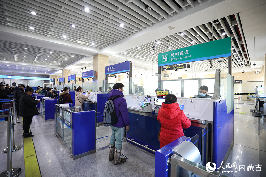 二連出入境邊防檢查站移民管理警察為旅客辦理通關手續。郭鵬杰攝