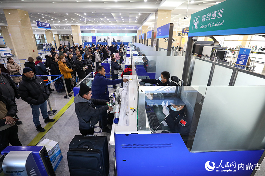 2024年12月9日,二連出入境邊防檢查站移民管理警察為旅客辦理通關(guān)手續(xù)。郭鵬杰攝