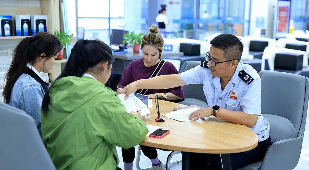 稅務干部在辦稅服務廳一對一輔導納稅人辦理業務。