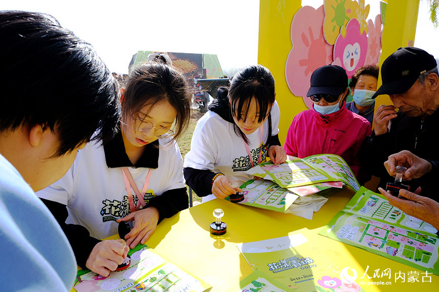 “花漾青城”2025呼和浩特賞花季系列文旅活動開啟，市民正在開幕式現(xiàn)場集章打卡。人民網(wǎng)記者 劉藝琳攝