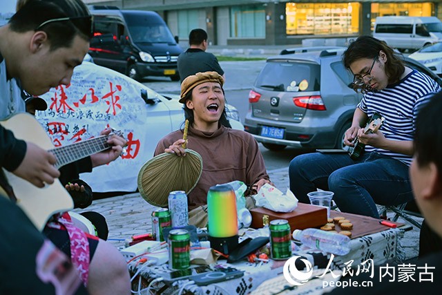 葉鎮(zhèn)豪(左二)與滿洲里當(dāng)?shù)氐哪贻p人在街頭高歌。人民網(wǎng)記者 寇雅楠攝