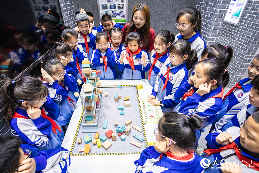 內蒙古呼和浩特市玉泉區通順街小學學生在地震科普館通過演示裝置了解建筑結構抗震知識。丁根厚攝