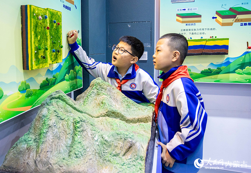 內蒙古呼和浩特市玉泉區通順街小學學生在地震科普館通過演示裝置了解地震平移斷層知識。丁根厚攝