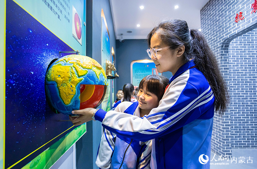 內蒙古呼和浩特市玉泉區通順街小學學生在地震科普館里通過模型了解地球內部構造。丁根厚攝