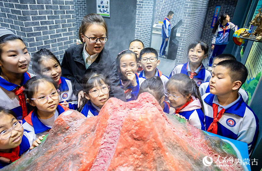 內蒙古呼和浩特市玉泉區通順街小學學生在地震科普館通過演示裝置了解火山噴發知識。丁根厚攝