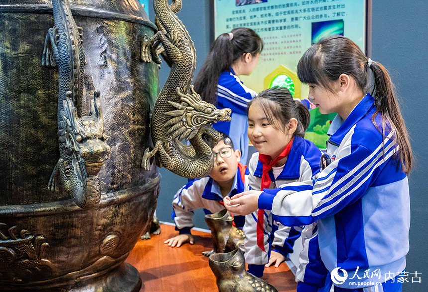 內蒙古呼和浩特市玉泉區通順街小學學生在地震科普館了解張衡地動儀模型的工作原理。丁根厚攝