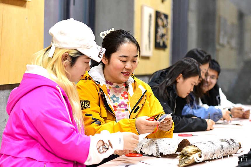 游客在阿爾山·泰康藝術中心藝術空間體驗樺樹皮畫制作技藝。王正攝