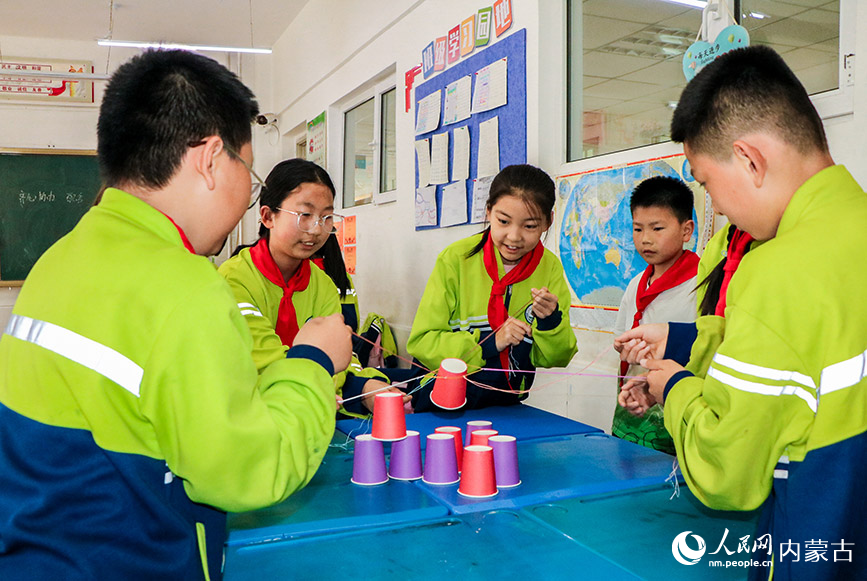 5月23日,呼和浩特市玉泉區青少年宮“流動少年宮”公益專列校園活動現場,學生在心理團輔互動成長《我們一起玩》課上做游戲。丁根厚攝